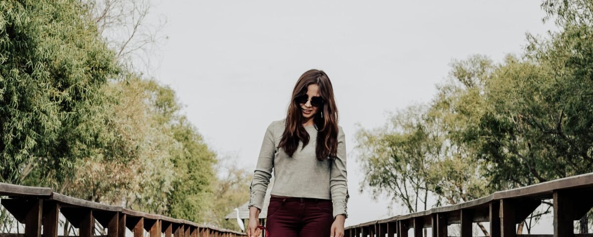 Woman Wearing Sunglasses Walking On Wooden Bridge With Her Dog